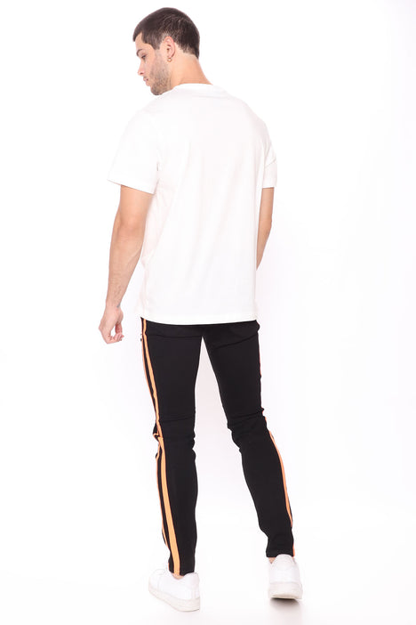 Black jeans with orange stripe top